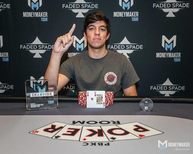 Ryan holding up his index finger in victory after winning the Moneymaker Tour at Palm Beach Kennel Club, with Ace-King and a champion's trophy on the table