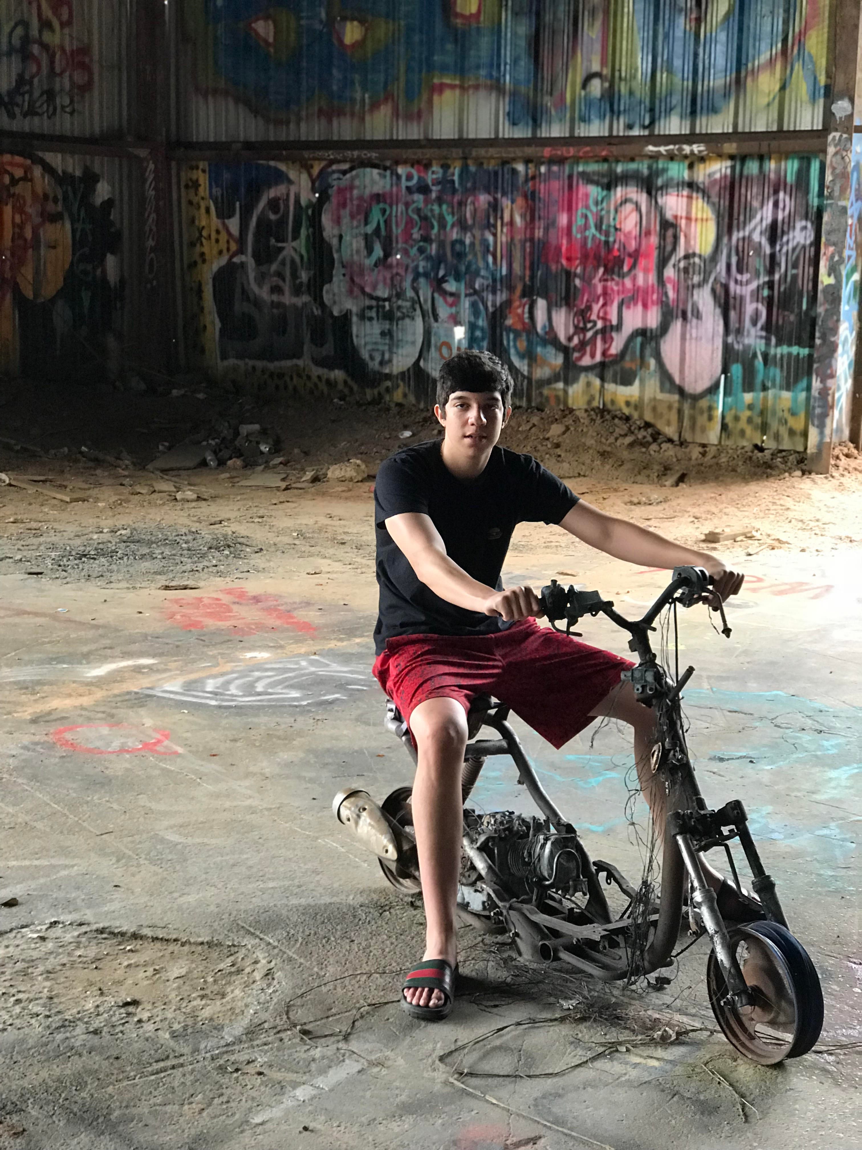 Ryan on a mini-bike under a graffiti tunnel