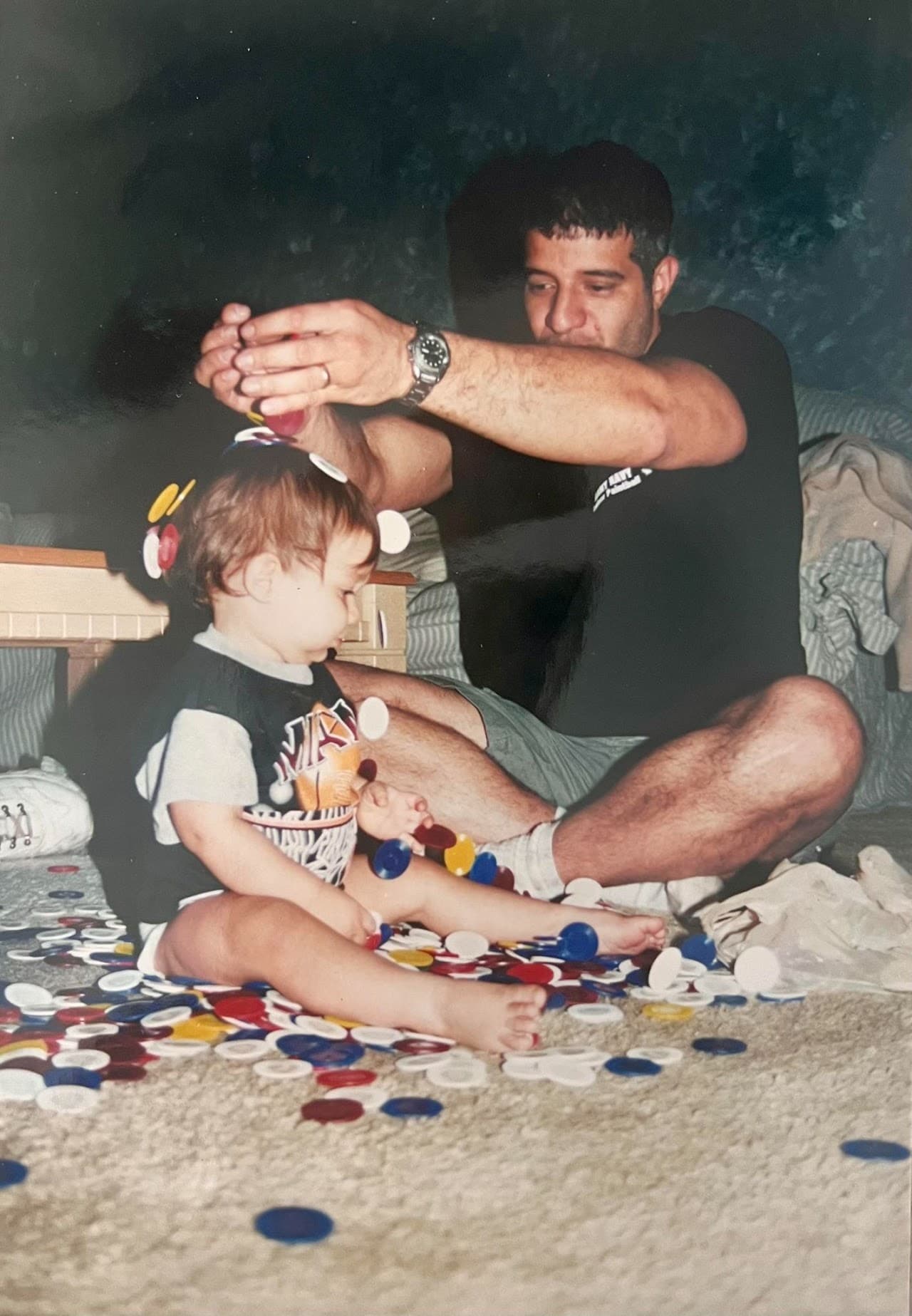 Ryan as a baby on the floor surrounded by hundreds of poker chips, with his father playing alongside him